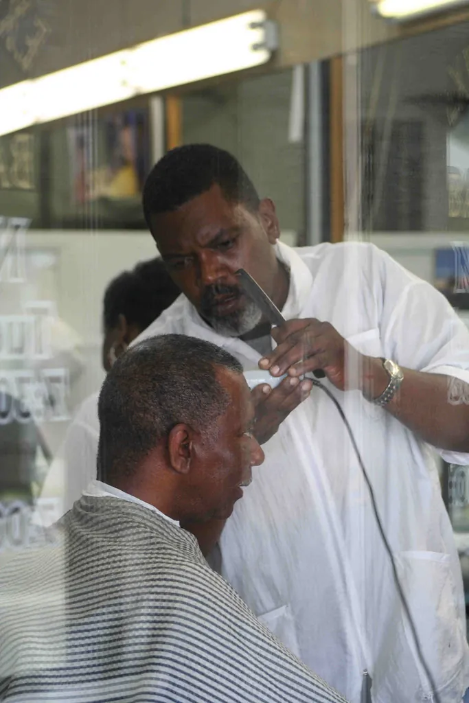 Barbero cortando el pelo a un cliente con dedicación